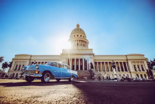 Rua colorida em Havana com carros clássicos e edifícios coloniais
