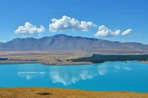 Travelers hiking in New Zealand with scenic mountain views.