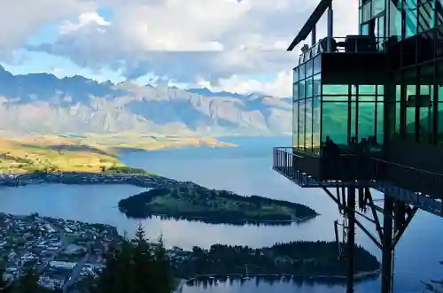 A panoramic view of Milford Sound or Queenstown with a couple hiking or enjoying the view.